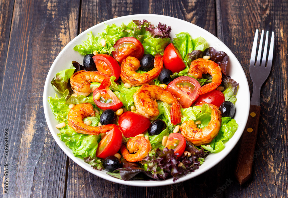 Salad with shrimps, tomatoes, olives and nuts. Healthy eating.