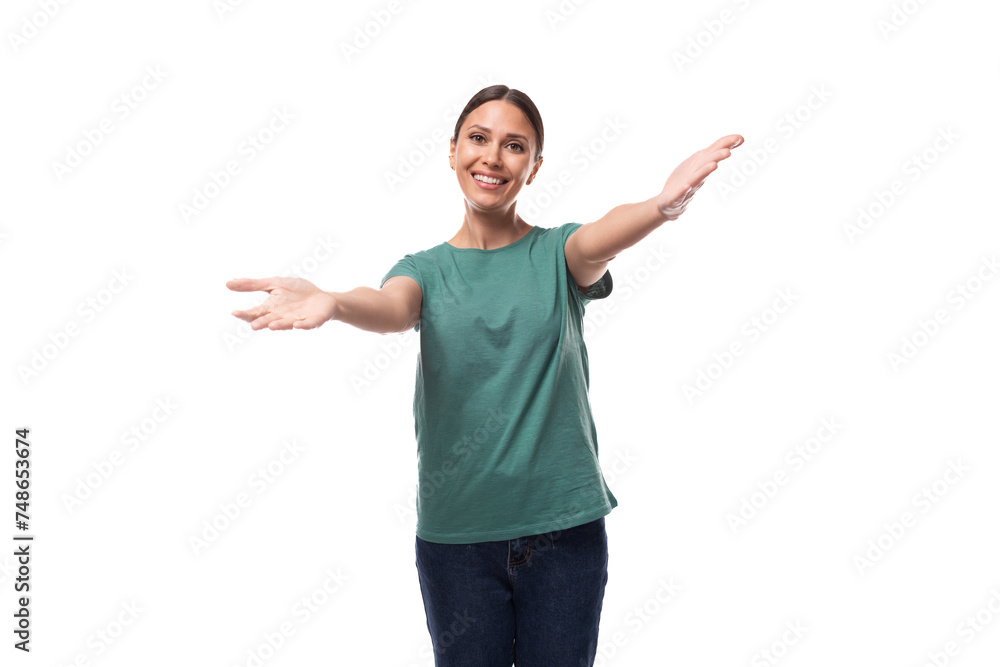 a young woman with black hair and a slim figure dressed in a green T-shirt smiles affably at the camera on a studio background with copy space a young woman with black hair and a slim figure dressed in a green T-shirt smiles affably at the camera on a studio background with copy space
