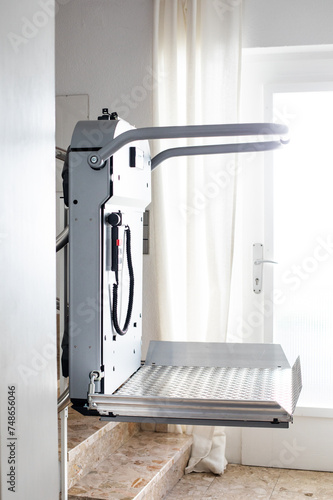 The stair lift in the residential building enables mobility for wheelchair users by transporting them safely and comfortably between floors