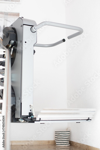 The stair lift in the residential building enables mobility for wheelchair users by transporting them safely and comfortably between floors