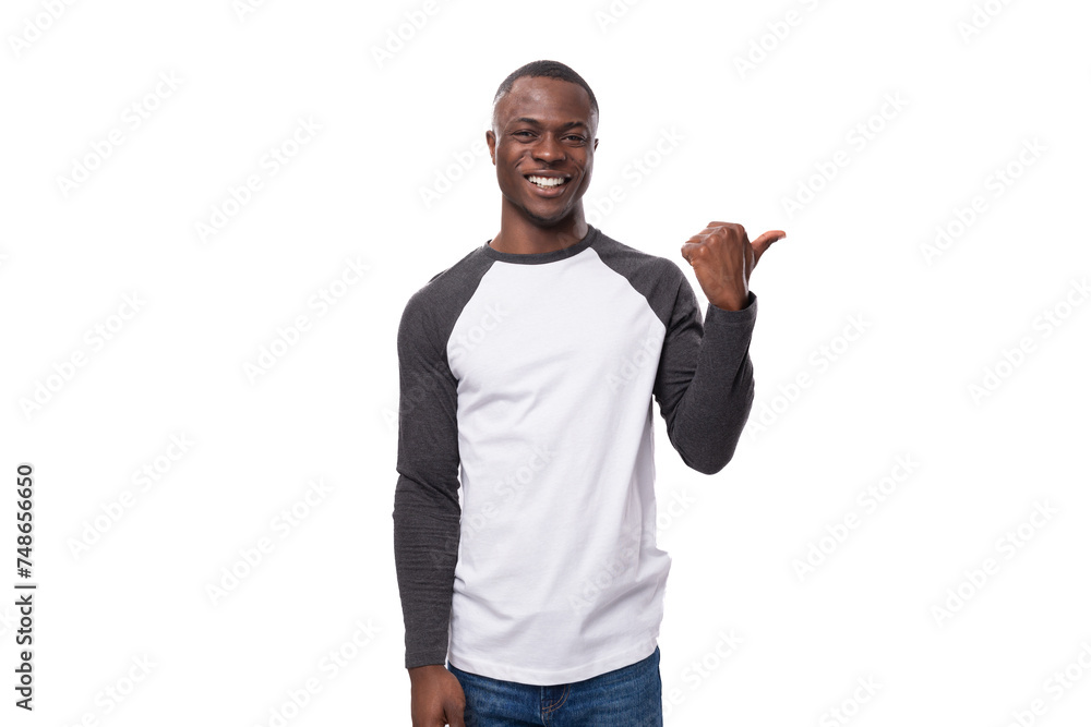 young american man with short haircut wearing long sleeved casual sweater pointing his finger to the side young american man with short haircut wearing long sleeved casual sweater pointing his finger to the side