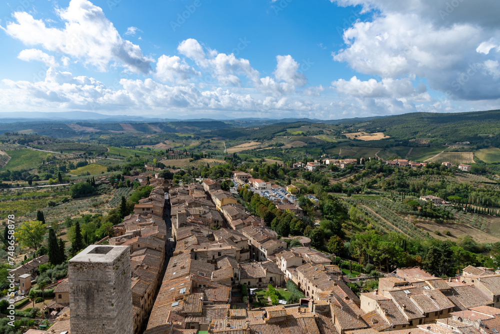 High angle panoramic view over San Gimignano, Italy with view on the tower Torre dei Cugnanesi  and typical Tuscan landscape in the background