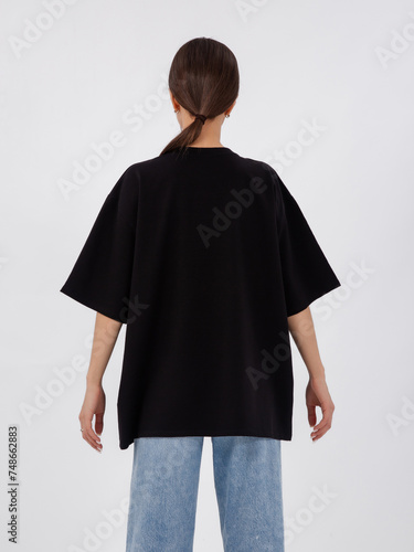 mockup of a black loose-fitting t-shirt on a young beautiful girl
