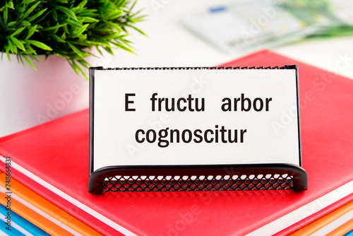 E fructu arbor cognoscitur the phrase in Latin translates as the Tree is known by its fruits on white business cards in delivery on a light background photo
