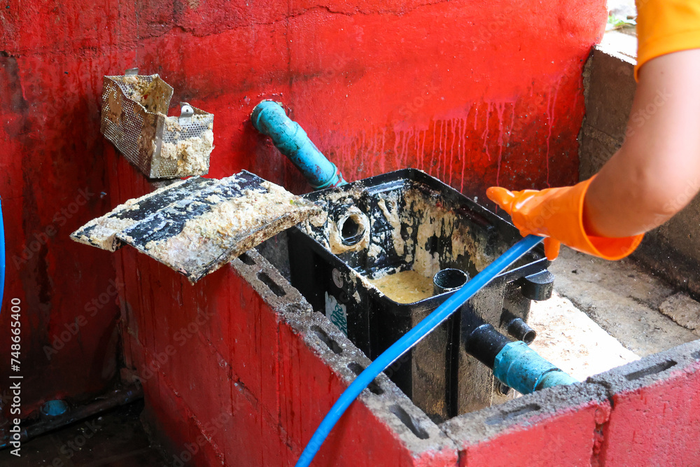 Grease traps from dirty debris being cleaned with a scoop are discarded