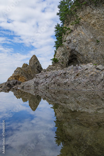 日本 青森県西津軽郡深浦町の仙北岩トンネル近くの水鏡に映った海岸の風景