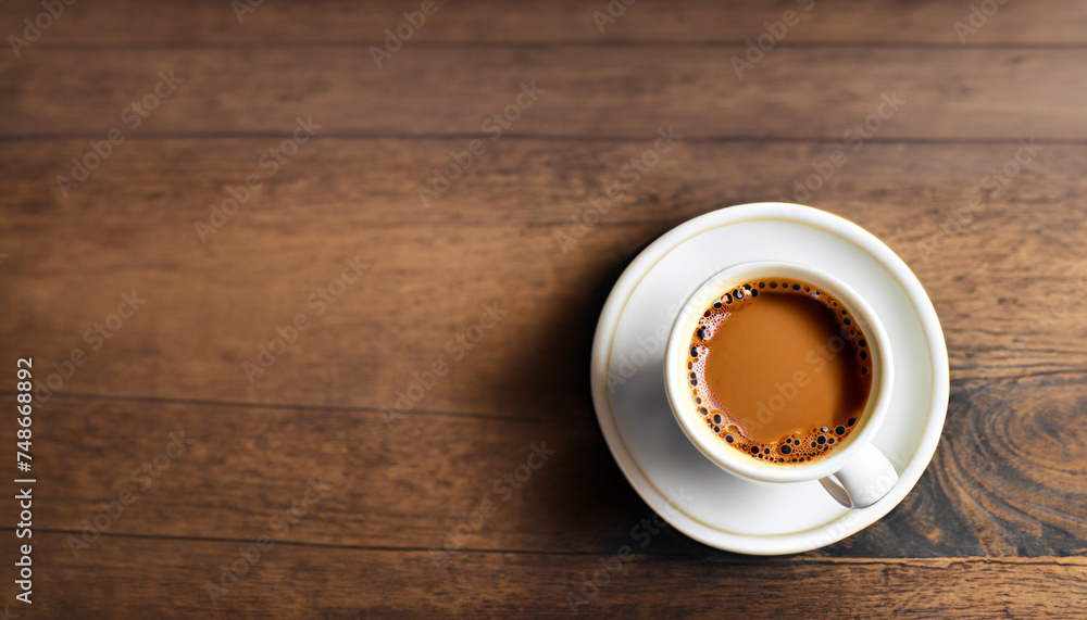 Cup of coffee on wooden table, top view; close up; dark brown background Cup of coffee on wooden table, top view; close up; dark brown background