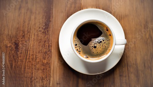 Cup of coffee on wooden table, top view; close up; dark brown background