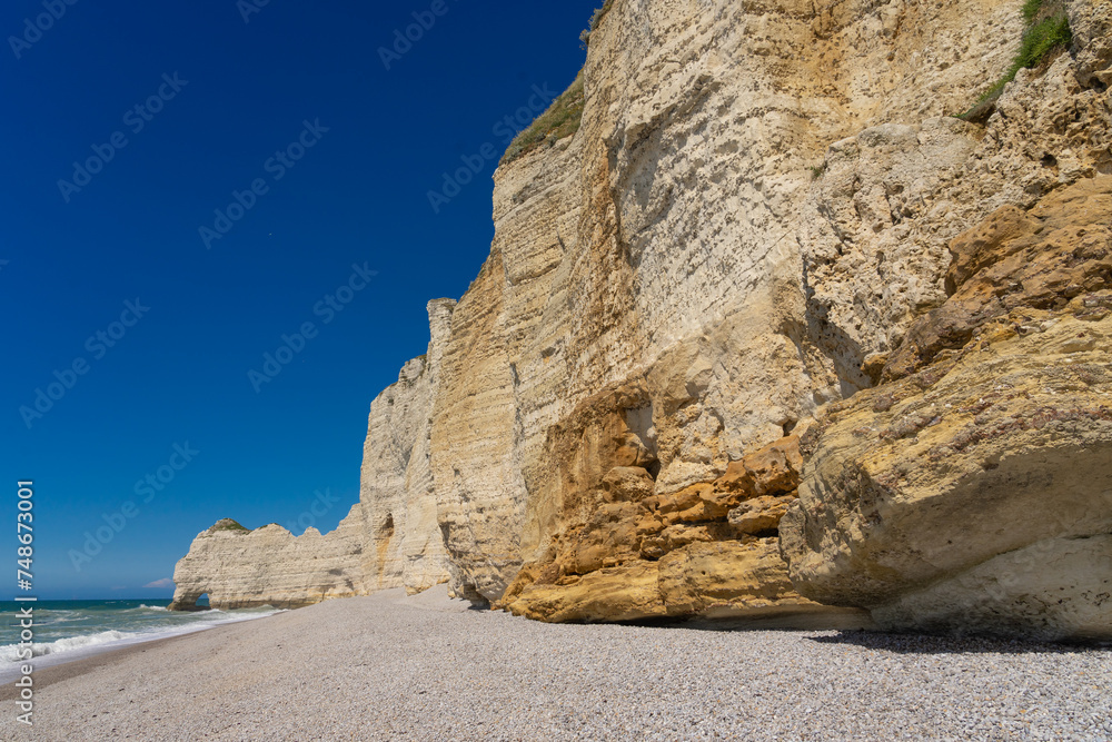 Etretat cliffs and beach in the Normandie region of France in a sunny day. Falaise d'amont chalk clliffs in the Alabaster coast.