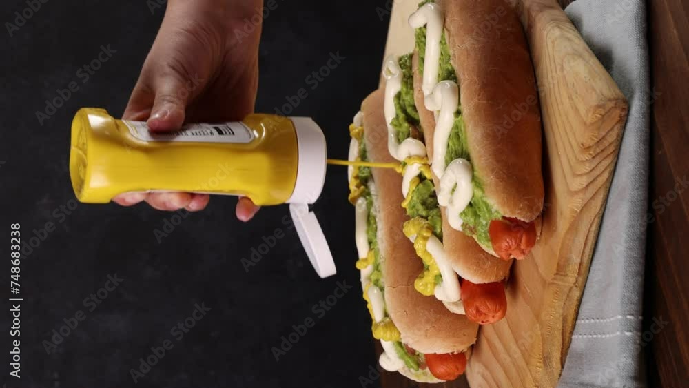 Chilean Typical Completo Food Hot dog with tomato, avocado palta and mayonnaise Selective Focus, vertical video