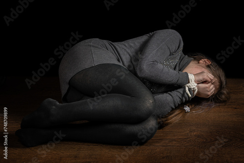 Tied girl on the floor. Stop abusing child violence, human trafficking, Human Rights Day concept photo