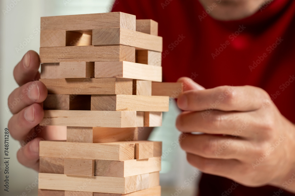 Planning, risk and strategy in business, businessman and engineer gambling placing wooden block on a tower Planning, risk and strategy in business, businessman and engineer gambling placing wooden block on a tower