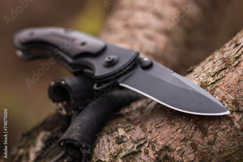 military tactical knife on tree in the forest