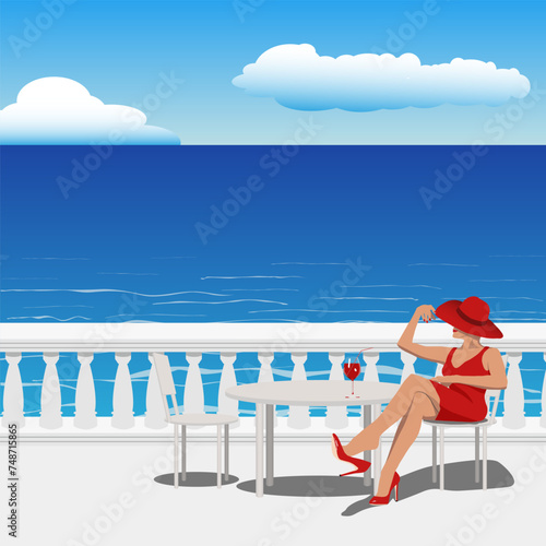 beautiful slender woman in a red dress and hat sits on a chair in a summer cafe on the embankment near the sea