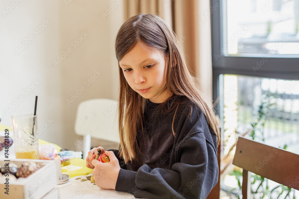 Young Girl Focused on Easter Egg Decorating Young Girl Focused on Easter Egg Decorating