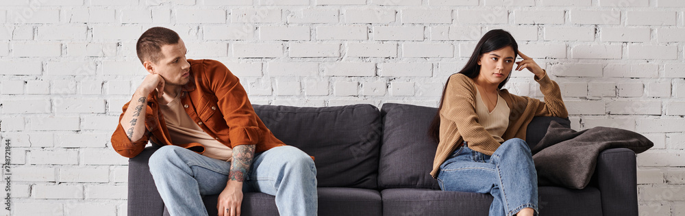 sad multicultural couple sitting on couch in living room at home, family divorce concept, banner sad multicultural couple sitting on couch in living room at home, family divorce concept, banner