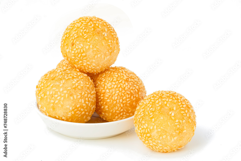Golden yellow Thai dessert Round balls mixed with sesame seeds and fried to a crispy, sweet taste. Fried sesame snacks on white background.