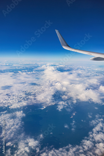 Airplane flying over color sky clouds and snowy mountains hills