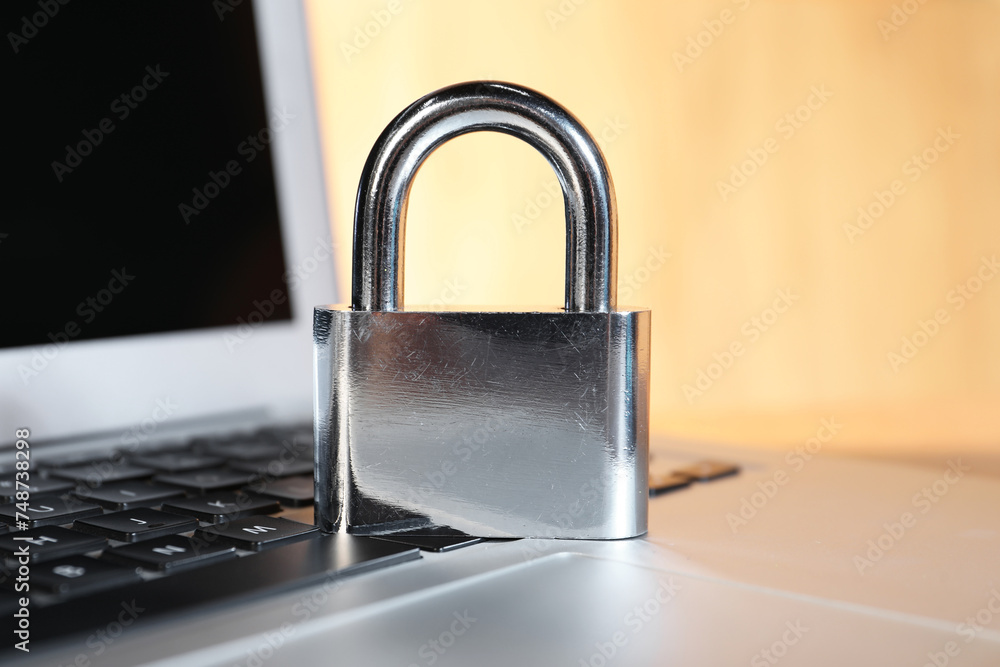 Fototapeta premium Cyber security. Padlock on laptop, closeup view
