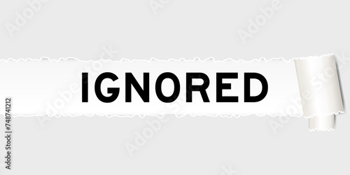 Ripped gray paper background that have word ignored under torn part