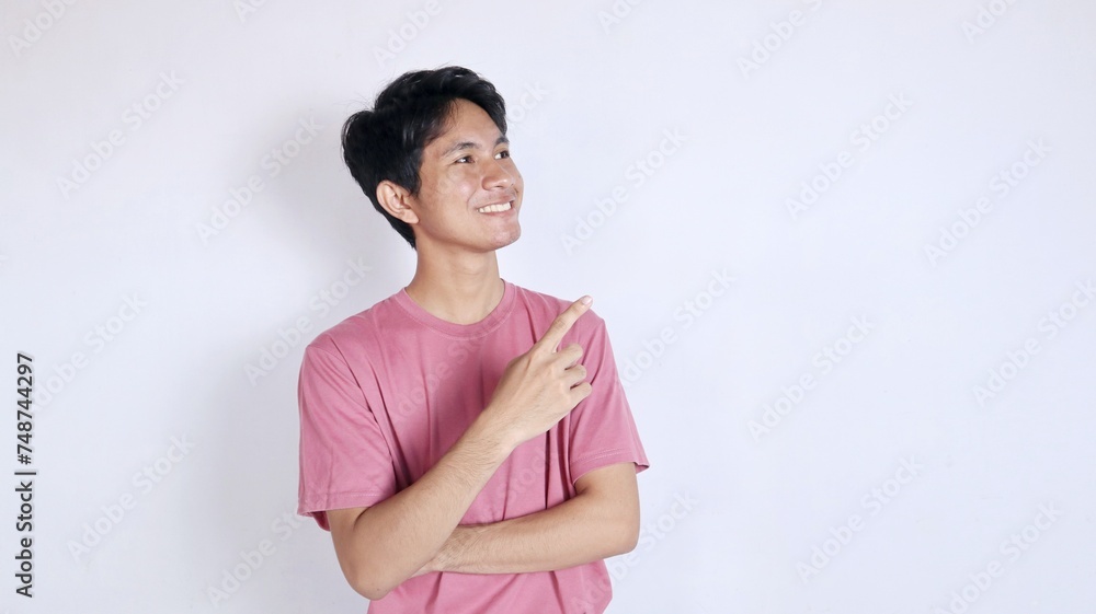 Asian man with an excited gesture pointing towards the side of the copy space Asian man with an excited gesture pointing towards the side of the copy space