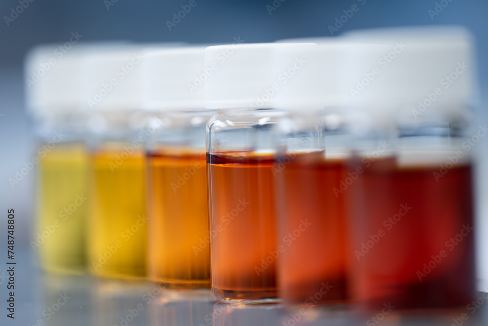 Several samples containing orange solution. Close up photo of chemical glass tube in a row. Several samples containing orange solution. Close up photo of chemical glass tube in a row.