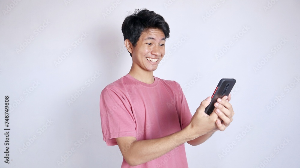 excited and smiling Asian man with smartphone holding gesture excited and smiling Asian man with smartphone holding gesture