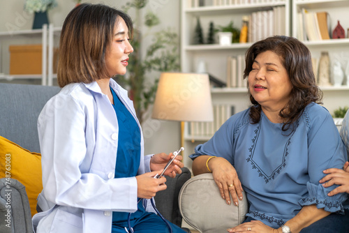 Female healthcare professional providing at home medical care to elderly woman with smile, senior patient, nursing, listens attentively to nurse, elderly care, home health services, patient at home