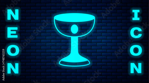 Glowing neon Christian chalice icon isolated on brick wall background. Christianity icon. Happy Easter. Vector