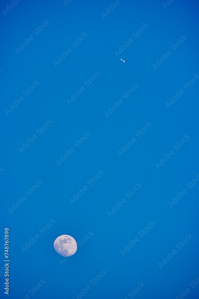 landscape with the moon and an airplane in the blue sky landscape with the moon and an airplane in the blue sky