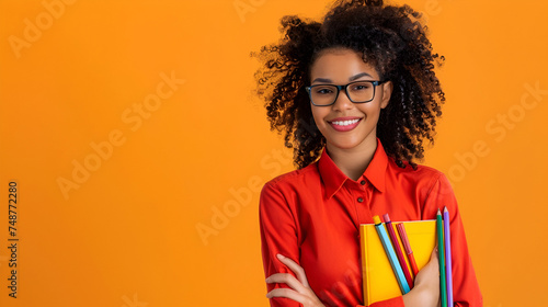 banner put on knowledge, smiling teacher holding textbooks on a yellow background close-up with space for text photo
