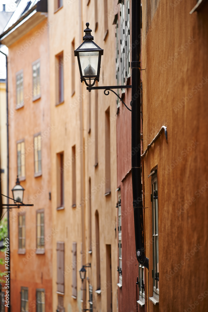 Travel, architecture and lamp in vintage alley of old town with history, culture or holiday destination in Sweden. Vacation, buildings and antique lantern in Stockholm with retro light ancient city