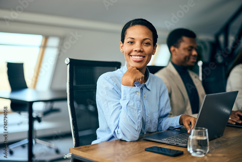 Portrait of a smiling black businesswoman, posing for the camera while having a meeting.