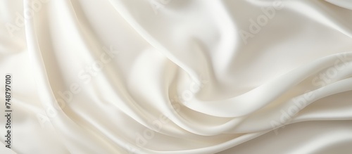 Detailed close up view of a white fabric with a soft, textured background. The fabric appears to be smooth and pristine, with subtle shadows enhancing its texture.