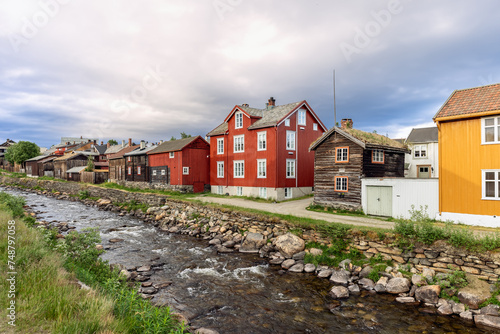 A picturesque view of Roros showcases historical buildings alongside the flowing Glomma River, reflecting Norway's rich cultural heritage