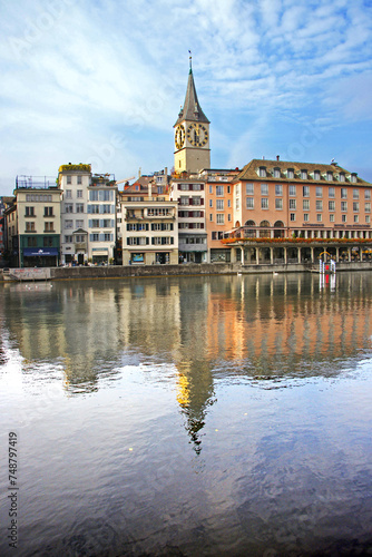 buildings of the historic center of the city of Zurich along the Limmat river, clock tower of the St. Peter church. 