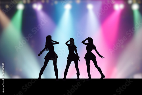 ステージ上の3人の女性アイドルとカラフルなスポットライト photo