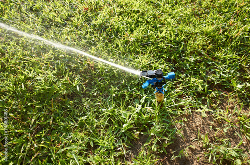 Sprinkler spraying water on the lawn.

