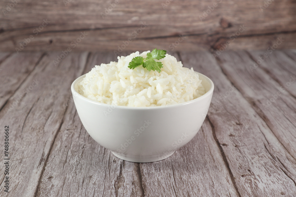 White rice in bowl on wood table. Close up White rice in bowl on wood table. Close up