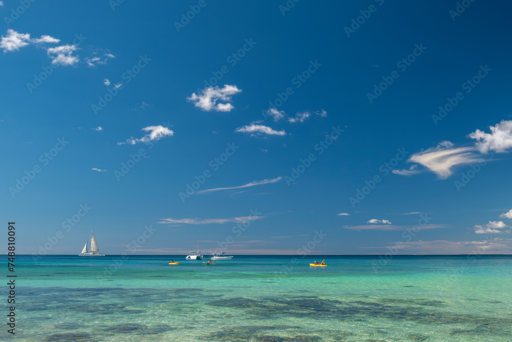 Seascape with crystal clear turquoise water, yachts, boats and people kayaking. South destination, vacation concept.