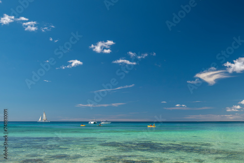 Seascape with crystal clear turquoise water, yachts, boats and people kayaking. South destination, vacation concept.