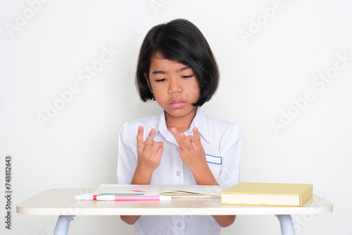 Indonesia kid student learning to count with her fingers photo