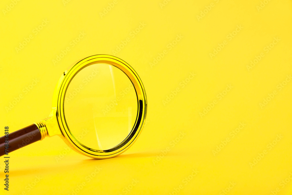 Magnifying glass in a gold frame on a yellow background. Copy space. Magnifying glass in a gold frame on a yellow background. Copy space.