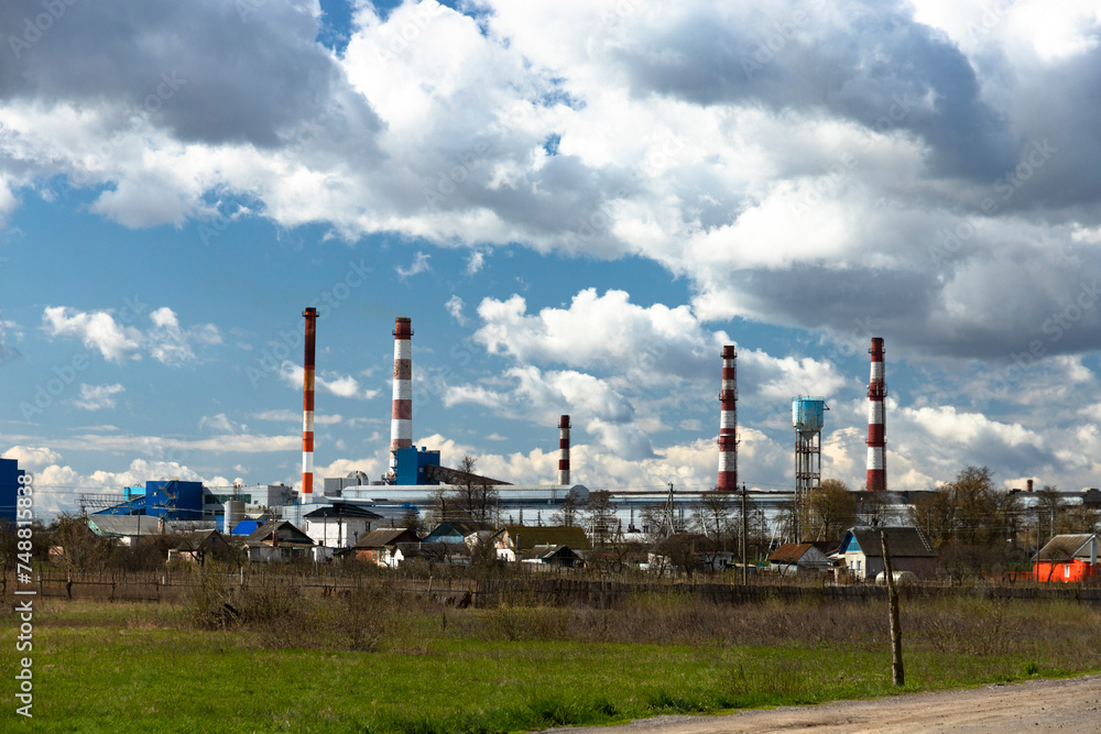 Industrial landscape of a glass factory with pipes, reservoir chimneys.