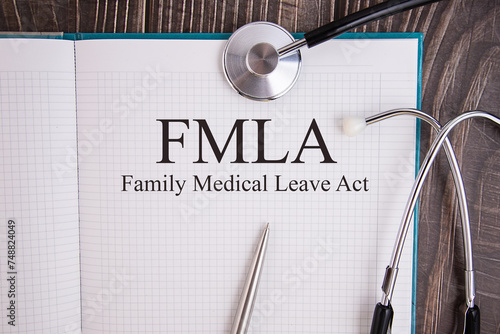 Page with, FMLA, Family Medical Leave Act on the table with stethoscope, medical concept photo