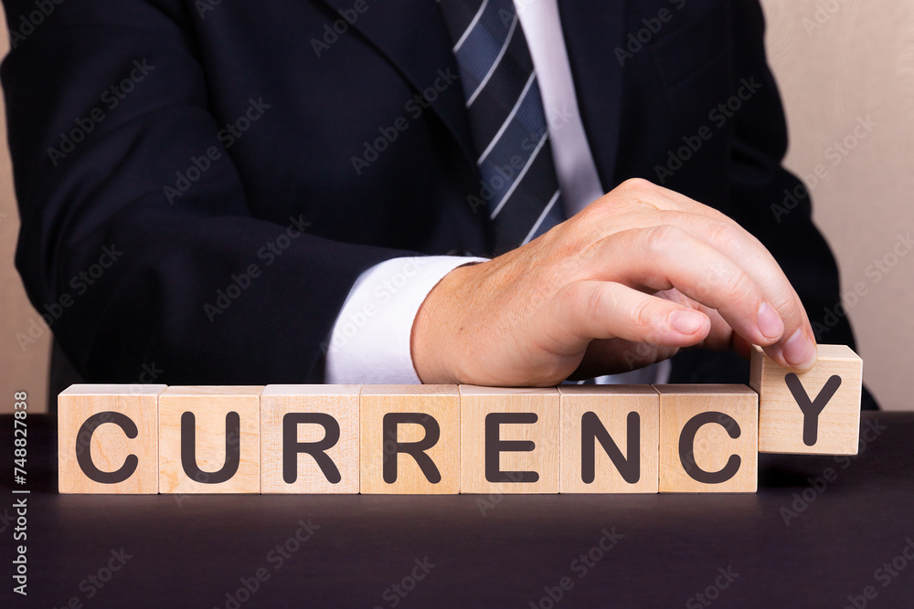 Obraz premium Man made word Currency with wood blocks