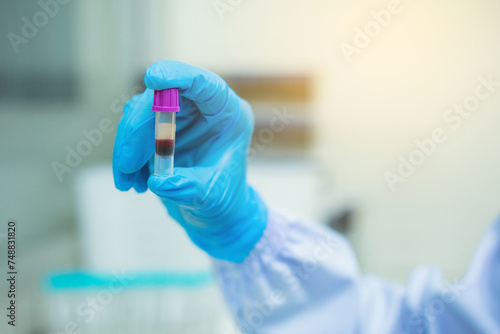 Scientists show blood in vitro. The process of research and development in laboratory science, surrounded by test tubes and pipettes.