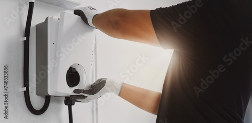 Photos Certified male Electrician Installing Home EV Charger