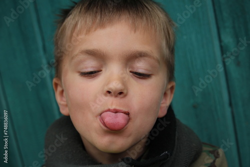 garçon tirant la langue , grimace