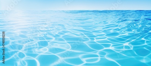 The image showcases a blue ocean with gentle ripples of water creating a mesmerizing pattern. The surface of the water reflects the sunlight, creating a shimmering effect.